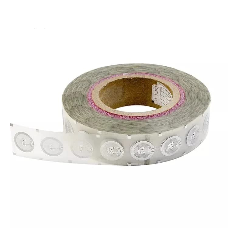 A roll of transparent NFC inlay stickers with circular patterns on a white background.