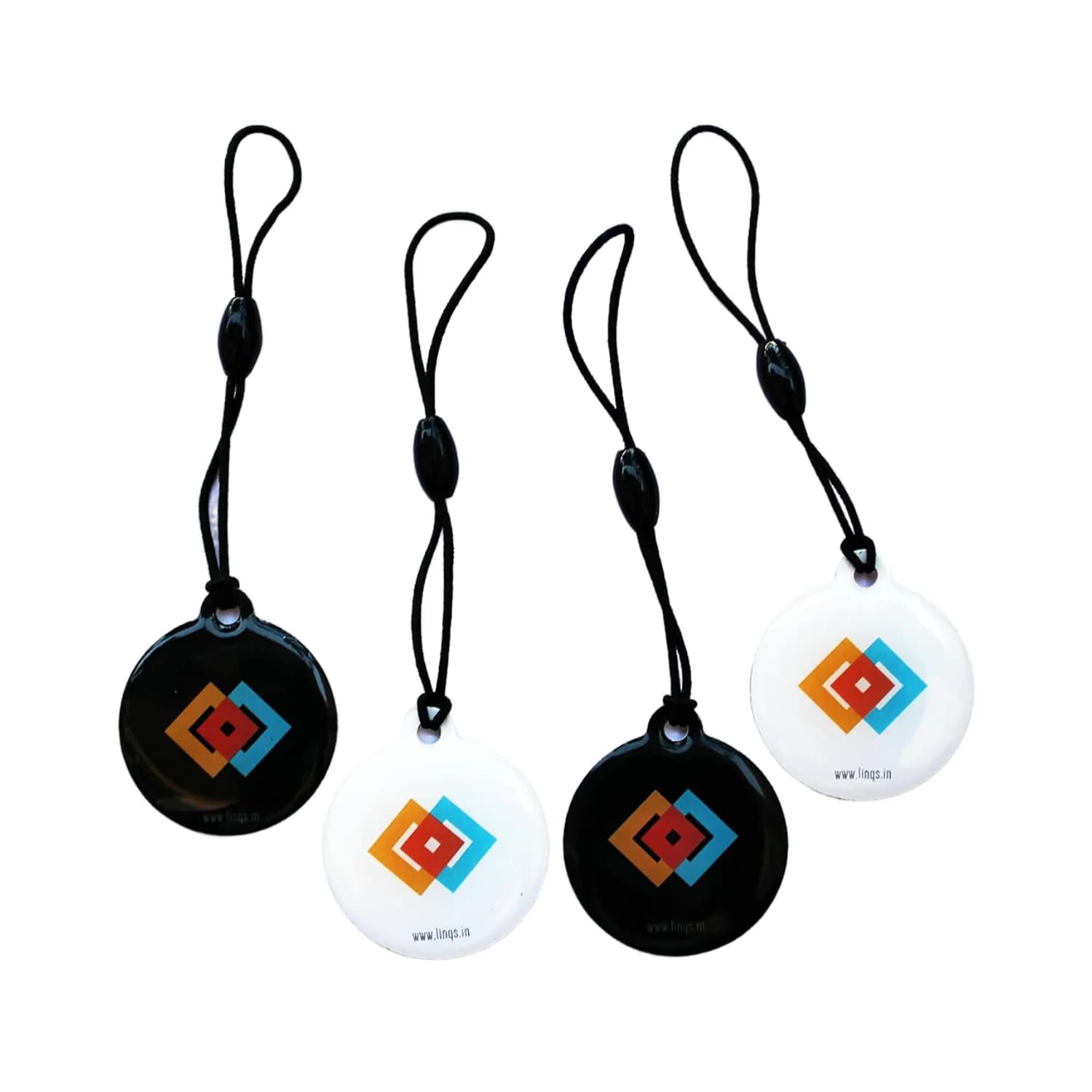 Four round hang tags with glossy black and white surfaces, featuring colorful geometric designs and strings for hanging.