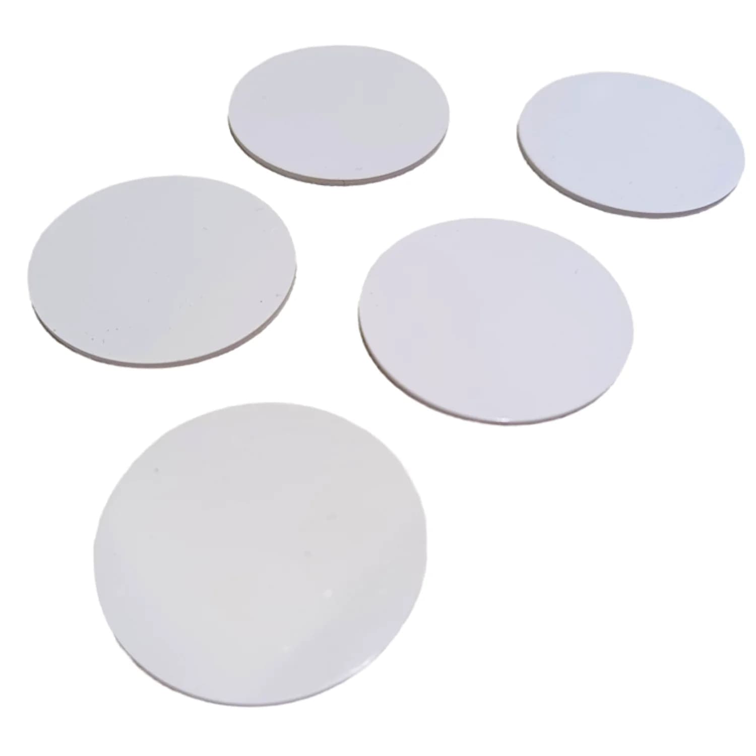 Five round, white coin-shaped NFC tags on a plain white background.