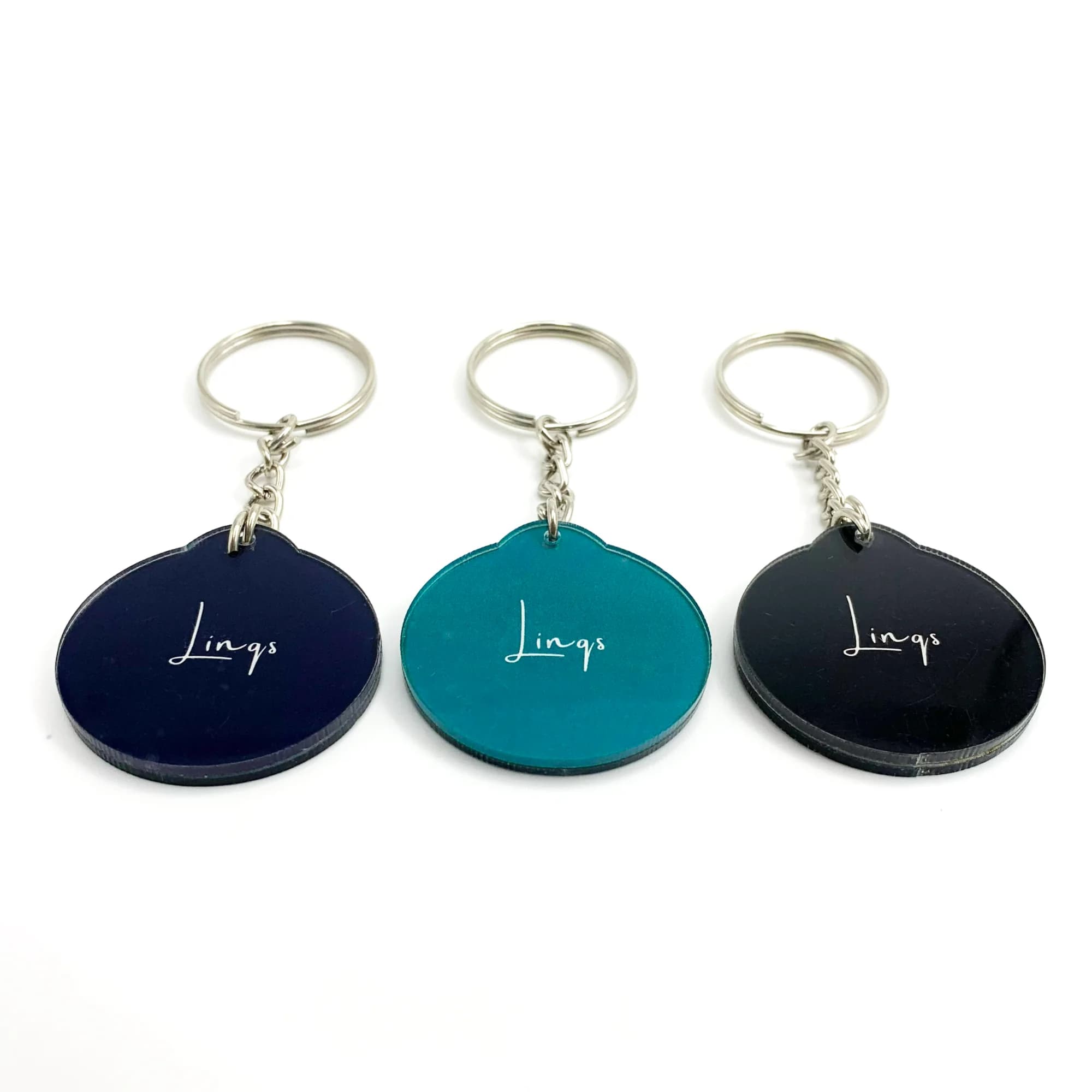 Three acrylic NFC keychains in black, teal, and navy blue with "Lings" written on each, attached to silver key rings.
